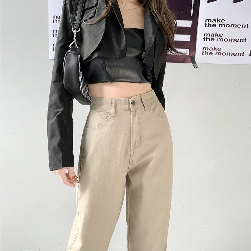 Damen-Jeans mit geradem Bein und hoher Taille in Beige, kombiniert mit schwarzer Jacke und Top. Modetrend, lässiger Stil, Streetwear.
