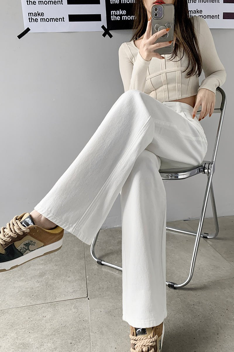 Damenmode: Weiße High-Waist-Jeans mit geradem Bein, kombiniert mit beigem Crop-Top. Trendige Streetwear, ideal für stilvolle Outfits.