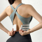 Grüner Sport-BH mit überkreuzten Trägern, ideal für Fitness und Yoga. Atmungsaktives Material, verstellbarer Verschluss, modisches Design.