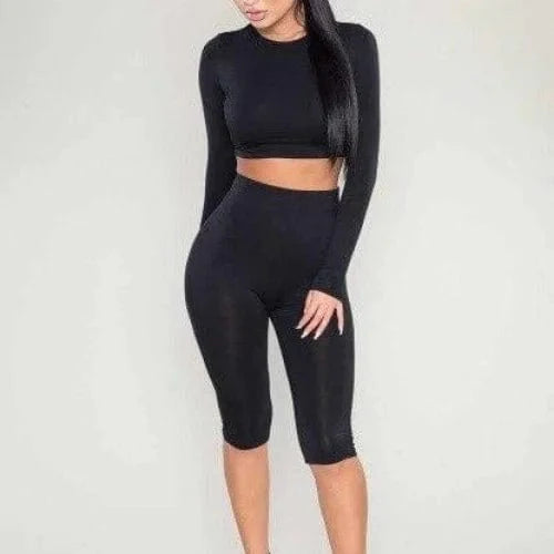 Schwarzes Sport-Set mit langen Ärmeln und Radlerhose, ideal für Fitness und Yoga. Atmungsaktives Material, modisch und funktional.