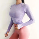 Sportliches Langarmshirt in Violett mit Daumenloch, ideal für Fitness und Yoga. Atmungsaktives Material, figurbetontes Design, Damenmode.