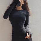 Schwarzes sportliches Damen-Top mit Daumenausschnitt, langärmelig, figurbetont, ideal für Fitness und Freizeit. Hochwertige, bequeme Passform.