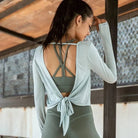 Sportliches Damen-Top mit Rückenausschnitt und Krawatten-Detail, ideal für Yoga und Fitness. Atmungsaktives Material, modisches Design.