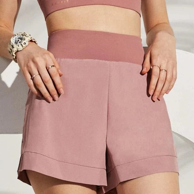 Rosa Sportshorts mit dekorativer Taille, ideal für Fitness und Freizeit. Bequemes Design, atmungsaktiver Stoff, modisch und funktional.