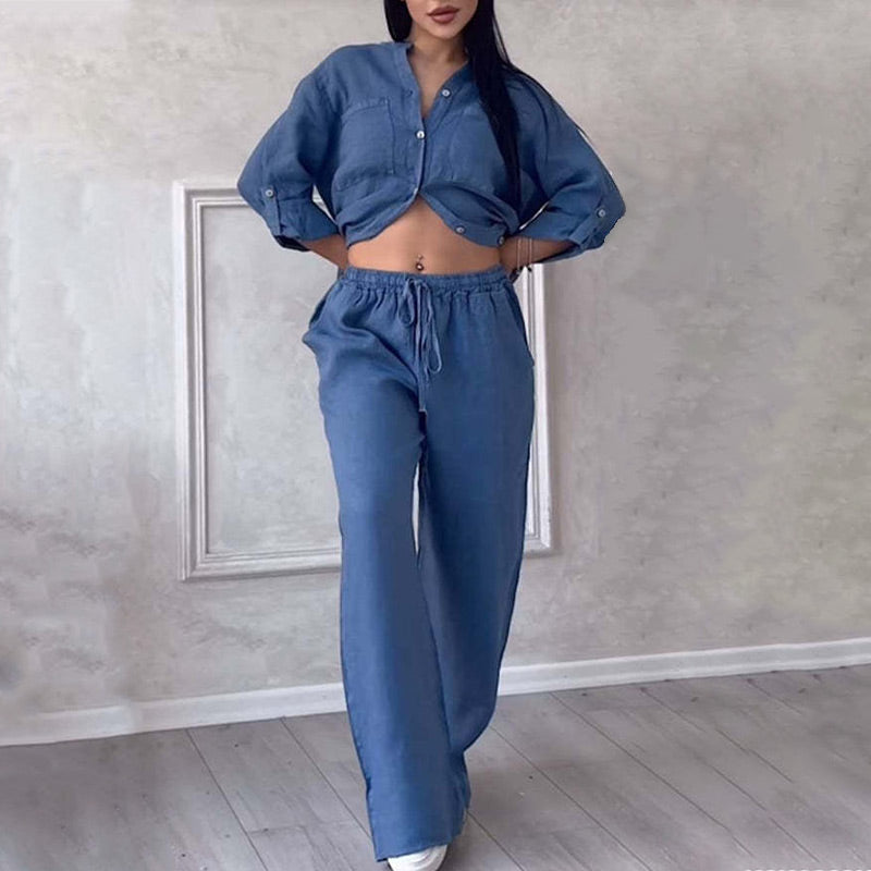 Frau in modischem blauen Denim-Set, bestehend aus Crop-Top und weiten Hosen. Trendige Damenmode, lässiger Look, Jeans-Outfit.