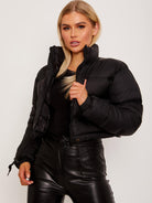 Schwarze Damen-Daunenjacke, modisch und warm, ideal für Wintermode. Perfekt kombinierbar mit Lederhosen für einen trendigen Look.