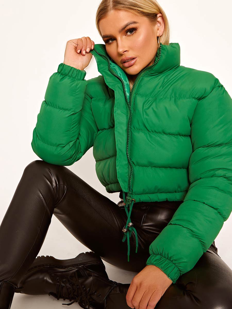 Grüne Daunenjacke Damen, modisch und warm, ideal für Wintermode. Kombiniert mit schwarzer Lederhose für trendigen Look. Perfekt für kalte Tage.