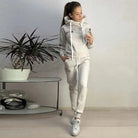 Damen-Sportset in Grau: Bequemes Hoodie und Jogginghose, ideal für Fitness und Freizeit. Perfekt für stilvolle Sportbekleidung und Loungewear.