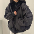 Schwarze Damenjacke mit Kapuze, Reißverschluss und Taschen, ideal für Wintermode. Stilvoll, warm und vielseitig für kalte Tage.