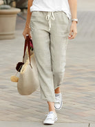 Damen Leinenhose in Apricot, lässig und bequem, ideal für Sommermode. Kombiniert mit weißen Sneakers und einer stilvollen Handtasche.