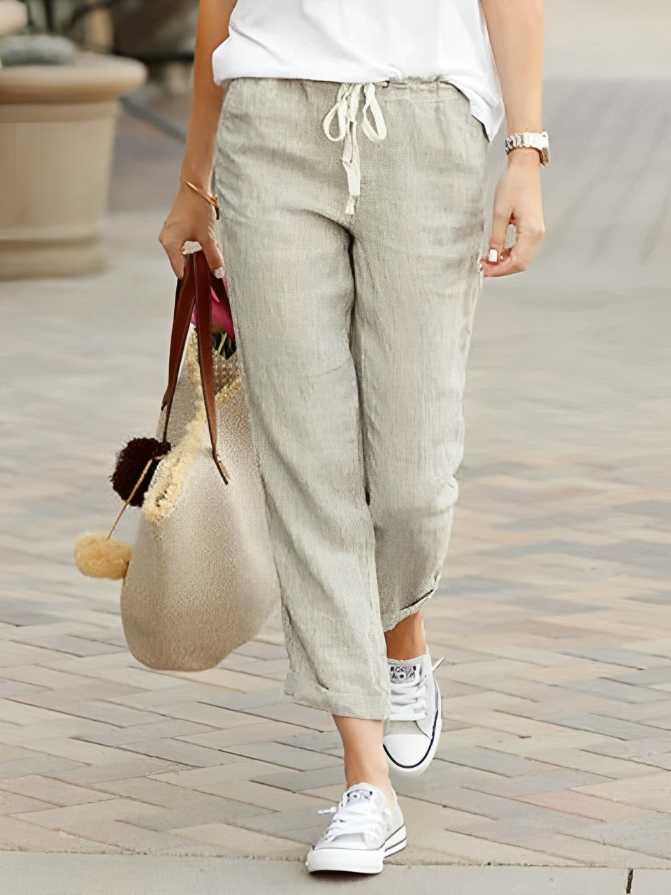 Damen Leinenhose in Apricot, lässig und bequem, ideal für Sommermode. Kombiniert mit weißen Sneakers und einer stilvollen Handtasche.