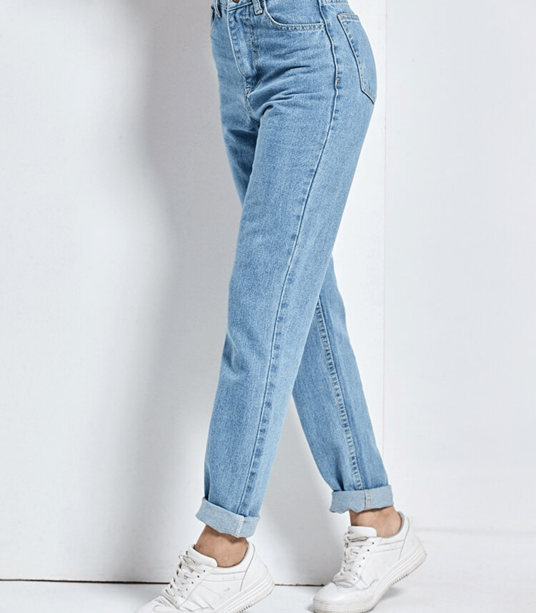 Vintage-Jeans mit hoher Taille in hellblauem Denim, lässig umgeschlagen, kombiniert mit weißen Sneakern. Perfekt für modische Retro-Looks.