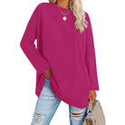 Damen Langarmshirt in kräftigem Pink, lässiger Stil, ideal für Freizeitmode. Kombiniert mit zerrissenen Jeans und modischer Handtasche.