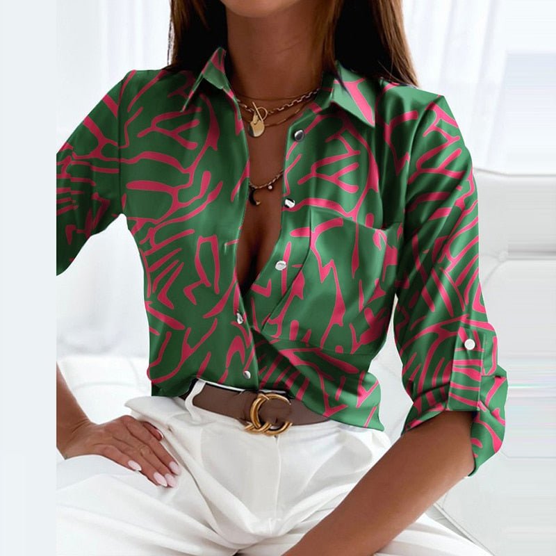 Grüne Bluse mit Umlegekragen und pinkem Muster, modisch und elegant, ideal für Damenmode. Perfekt für stilvolle Outfits und trendige Looks.