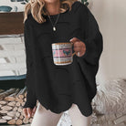 Damenpullover in Schwarz, gestrickt, lässiger Stil, ideal für Herbstmode. Perfekt kombiniert mit einer Tasse Kaffee für gemütliche Stunden.