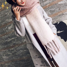 Frau in grauem Mantel mit rosa Schal, modisch und elegant. Wintermode, Damenbekleidung, stilvoller Look, warme Accessoires, Trend 2023.