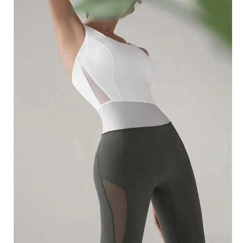 Zweifarbiges Sportoutfit für Damen, einteilig, mit weißem Oberteil und schwarzer Hose. Ideal für Fitness, Yoga und aktive Freizeit.