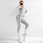 Zweifarbiges Sportset für Damen in Grau-Weiß, bestehend aus langärmligem Oberteil und Leggings. Ideal für Fitness und Yoga.