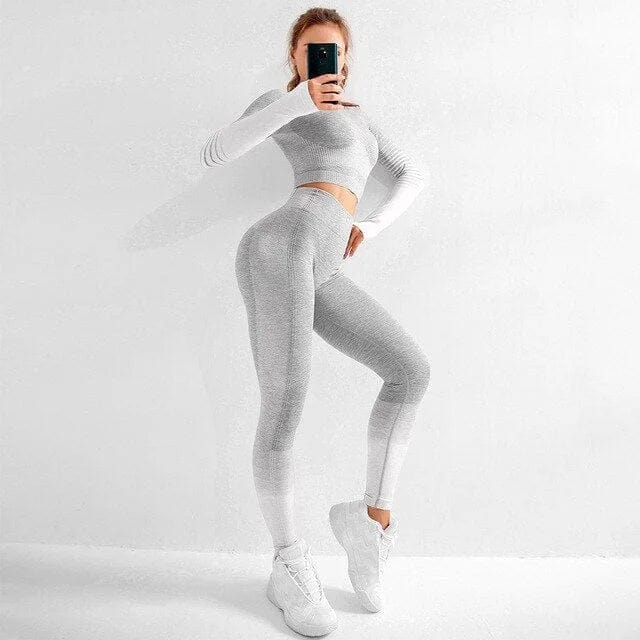 Zweifarbiges Sportset für Damen in Grau-Weiß, bestehend aus langärmligem Oberteil und Leggings. Ideal für Fitness und Yoga.